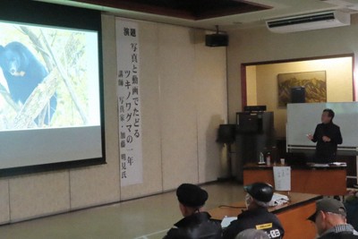 撮影したクマの写真をスライドで見せながら講演する写真家の加藤明見さん（右）＝秋田県横手市で2026年1月25日、工藤哲撮影