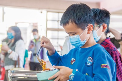 給食をよそう小学生。食材費高騰で給食の質や量の確保が一層求められている  桃園市（台湾北西部）提供