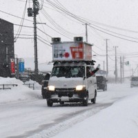 吹雪の中を走る選挙カー＝山形県鶴岡市で2026年1月29日午前7時49分、長南里香撮影（画像の一部を加工しています）