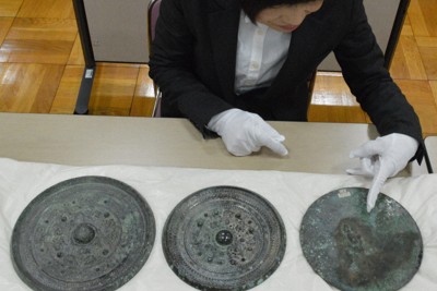 天理参考館所蔵の三角縁神獣鏡3面。右端の1面は鏡面側で、指さしている箇所が富雄丸山古墳出土品と一致した金属痕＝奈良県天理市の天理参考館で2026年1月30日午前11時1分、皆木成実撮影