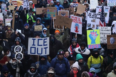 「ICE（移民・税関捜査局）は出て行け」などと書かれたボードを掲げて路上を埋め尽くしたデモ参加者＝米中西部ミネアポリスで2026年1月30日、八田浩輔撮影
