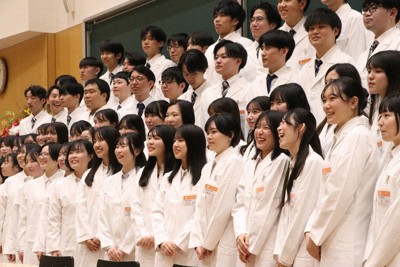 授与された白衣を着て記念撮影に収まる薬学部の学生＝山口県山陽小野田市大学通の山口東京理科大で2026年1月23日午後1時33分、綿貫洋撮影