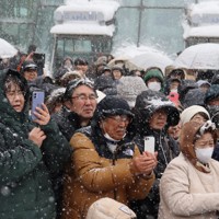 雪の中、JR札幌駅前での街頭演説に集まり、応援弁士らにスマートフォンを向ける支持者＝札幌市中央区で2026年1月31日午後1時14分、後藤佳怜撮影