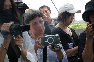 長生炭鉱の潜水調査に合わせて来日し、スマートフォンで記録動画を撮るガルミッシュさん（左から2人目）＝山口県宇部市で2025年8月27日、綿貫洋撮影