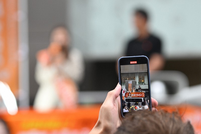 参政党・神谷宗幣代表らの街頭演説を撮影する聴衆のスマートフォン＝大阪市中央区で2025年7月17日、大西岳彦撮影