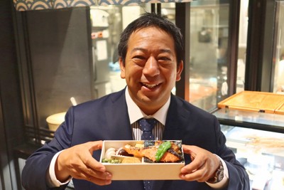 「八重八」の弁当を手にする山岡照幸ヤンマーホールディングス執行役員。同氏が社長を務めるヤンマーマルシェが運営しており、コメなど素材にこだわり昼時には行列ができる＝東京都中央区で2025年9月4日午後3時