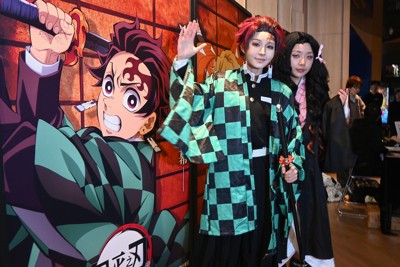 劇場版「鬼滅の刃」の上映前に記念撮影するコスプレ姿のファン（2025年11月、上海）　共同通信