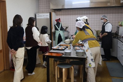 「十日市こども食堂おてらごはん」の台所に集まるスタッフや利用者＝広島市中区で、武市智菜実撮影