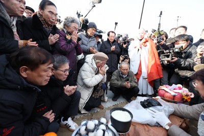長生炭鉱から収容された頭蓋骨とみられるものと対面し、手を合わせる事故の遺族ら＝山口県宇部市で2026年2月6日午後3時25分、後藤由耶撮影
