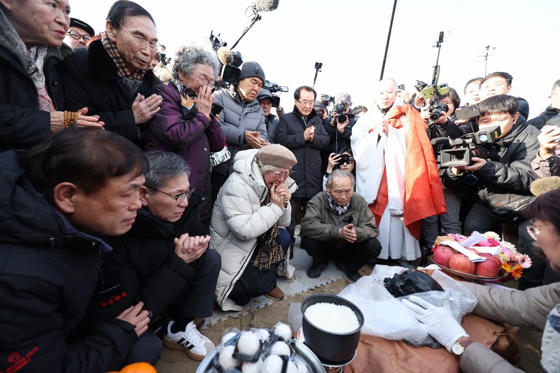 長生炭鉱から収容された頭蓋骨とみられるものと対面し、手を合わせる事故の遺族ら＝山口県宇部市で2026年2月6日午後3時25分、後藤由耶撮影