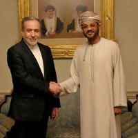　オマーンのバドル外相（右）と握手するイランのアラグチ外相＝6日、マスカット（イラン外務省/WANA提供、ロイター＝共同）