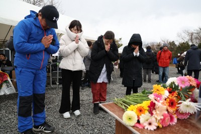 長生炭鉱の坑口付近に設けられた献花台で、潜水中に亡くなったダイバーのために手を合わせる人たち＝山口県宇部市で2026年2月7日午後3時43分、後藤由耶撮影