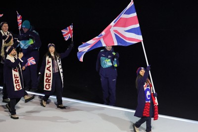先頭で国旗を手に行進する英国の女性旗手＝イタリア・ミラノのジュゼッペ・メアッツァ競技場で2026年2月6日、吉田航太撮影