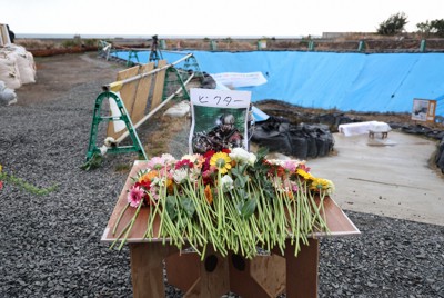 長生炭鉱の坑口前に設けられた、潜水中に亡くなったダイバーのための献花台。左奥の海上には2本のピーヤが見える＝山口県宇部市で2026年2月7日午後3時42分、後藤由耶撮影