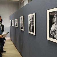 水俣病をテーマにした写真作品を見て回る来場者ら＝熊本市中央区の熊本大五高記念館で2026年2月4日午前11時