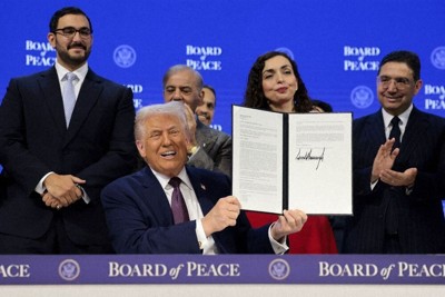 「平和評議会」の設立に関する文書に署名し、笑顔で文書を掲げるトランプ米大統領＝スイス・ダボスで1月22日、ロイター