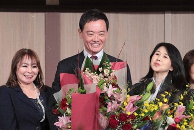 当選が確実となり、支援者から花束を受け取って笑顔を見せる中田宏氏（中央）＝富山市で2026年2月8日午後8時13分、岩本一希撮影