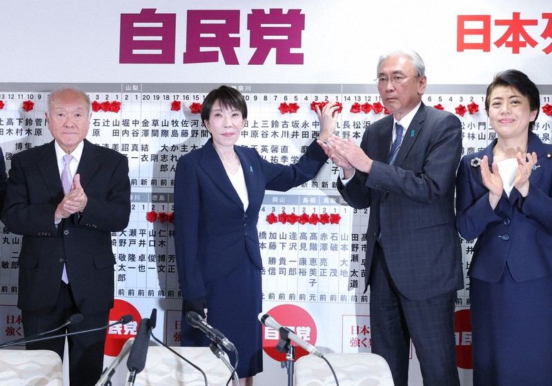 自民党開票センターで当選が確実となった候補者の名前に花をつける高市早苗首相（左から2人目）＝東京都千代田区で2026年2月8日午後9時42分、中川祐一撮影