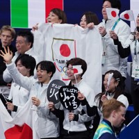 団体ペアのフリーで演技に臨む三浦璃来、木原龍一組に声援を送る日本の選手たち＝ミラノ・アイススケートアリーナで2026年2月8日、吉田航太撮影