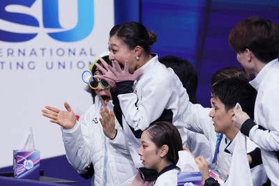団体女子のフリーで演技を終え、得点を見て飛び上がる坂本花織（中央）と鍵山優真（左）ら＝ミラノ・アイススケートアリーナで2026年2月8日、吉田航太撮影