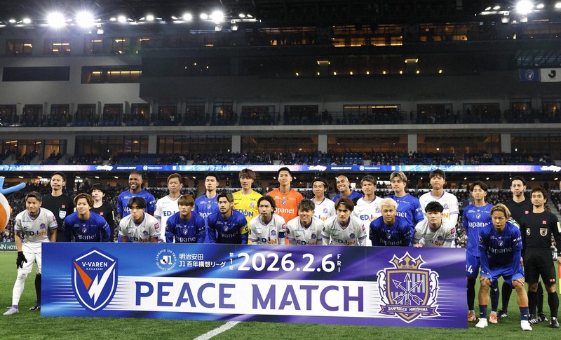 試合開始前に写真に納まる長崎と広島の選手ら＝ピーススタジアムで2026年2月6日