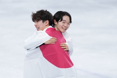 笑顔で抱き合う2位の鍵山優真（右）と3位の佐藤駿＝ミラノ・アイススケートアリーナで2026年2月13日、吉田航太撮影