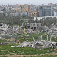 戦闘で破壊された建物の近くに、イスラエル軍の撤退ラインを示す黄色い標識が見える＝パレスチナ自治区ガザ地区中部デルバラーで2026年2月12日午後3時20分、松岡大地撮影