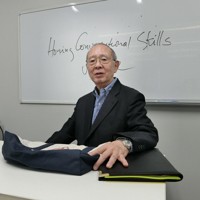 日米会話学院の授業で、ニュースで取り上げられた買い物袋を示して解説した杉田敏さん＝2026年1月10日、東京都新宿区で長野宏美撮影