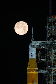This photo provided by NASA shows a full moon shining over NASA's Space Launch System and Orion spacecraft, atop the mobile launcher at Launch Pad 39B at the Kennedy Space Center in Florida, on Feb. 1, 2026. (Sam Lott/NASA via AP)
