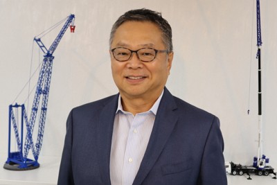 タダノの建設用クレーンのミニチュアの前に立つ氏家俊明社長＝東京都中央区で、山越峰一郎撮影