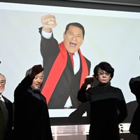 バーチャル映像の「AI猪木」とともに拳を振り上げる開発関係者ら＝東京都千代田区で2026年2月19日午後2時24分、山口智撮影