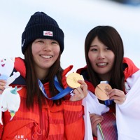 スノーボード女子スロープスタイル、金メダルを手に喜ぶ深田茉莉（左）と銅メダルの村瀬心椛＝リビーニョ・スノーパークで2026年2月18日、滝川大貴撮影