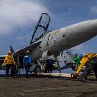空母エーブラハム・リンカーンの甲板で艦載機の準備をする乗組員＝インド洋で2026年1月21日（米海軍提供・AP）