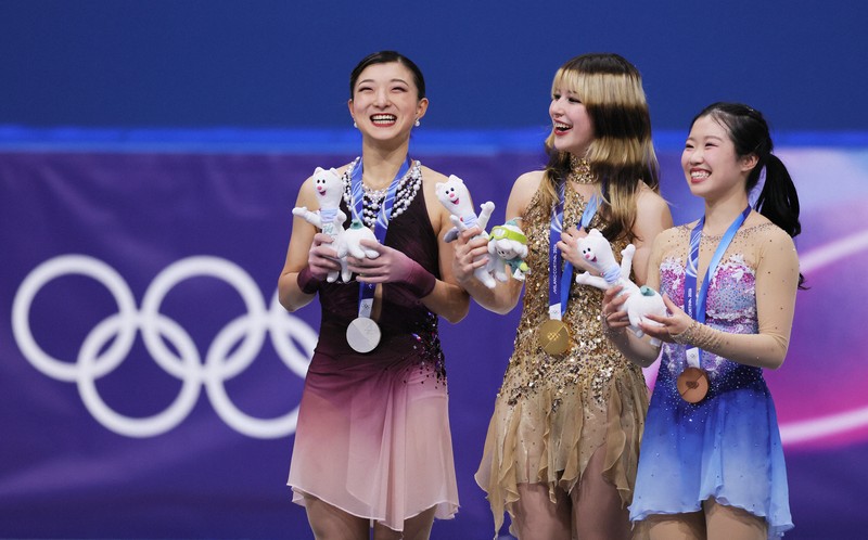 表彰式でメダルと公式マスコットを手に笑顔を見せる（左から）2位の坂本花織、1位の米国のアリサ・リュウ、3位の中井亜美＝ミラノ・アイススケートアリーナで2026年2月19日、吉田航太撮影