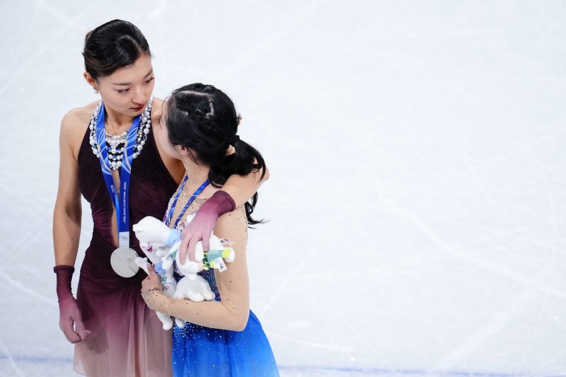 何かを中井亜美（手前）から言われ、真顔で見つめる坂本花織＝ミラノ・アイススケートアリーナで2026年2月19日、貝塚太一撮影