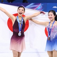 表彰式で日の丸を背にする銀メダルの坂本花織（左）と銅メダルの中井亜美＝ミラノ・アイススケートアリーナで2026年2月19日、猪飼健史撮影