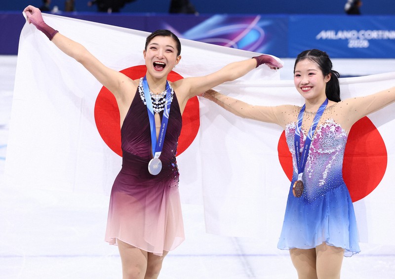 表彰式で日の丸を背にする銀メダルの坂本花織（左）と銅メダルの中井亜美＝ミラノ・アイススケートアリーナで2026年2月19日、猪飼健史撮影