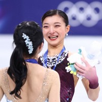 表彰式で顔をぬいぐるみで覆った後、笑顔を見せる銀メダルの坂本花織＝ミラノ・アイススケートアリーナで2026年2月19日、猪飼健史撮影