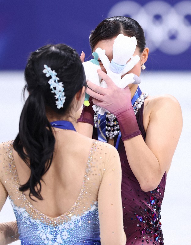 表彰式で顔をぬいぐるみで覆う銀メダルの坂本花織＝ミラノ・アイススケートアリーナで2026年2月19日、猪飼健史撮影