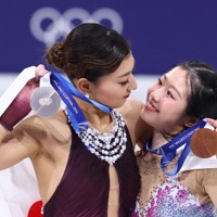 表彰式で銀メダルを手に笑顔を見せる坂本花織（左）と銅メダルの中井亜美＝ミラノ・アイススケートアリーナで2026年2月19日、猪飼健史撮影