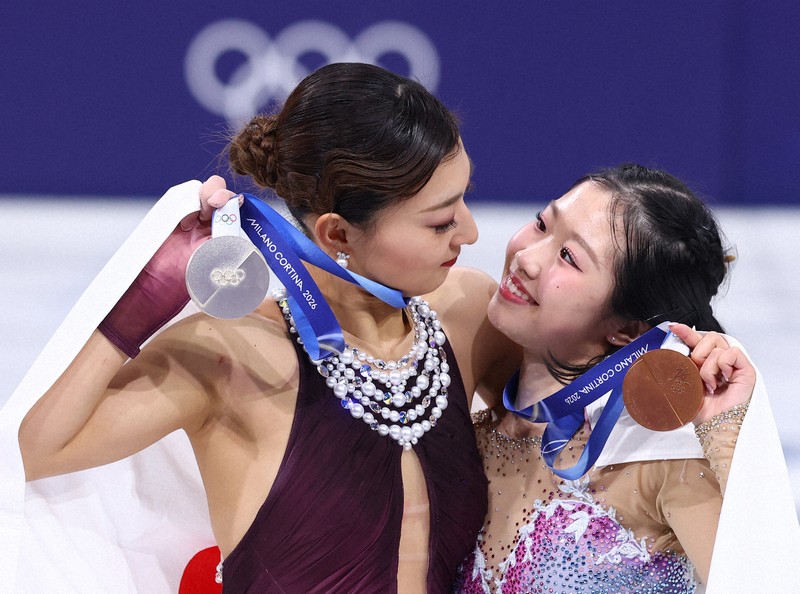 表彰式で銀メダルを手に笑顔を見せる坂本花織（左）と銅メダルの中井亜美＝ミラノ・アイススケートアリーナで2026年2月19日、猪飼健史撮影