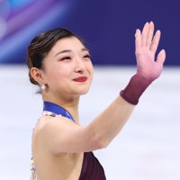 表彰式で観客に手を振る坂本花織＝ミラノ・アイススケートアリーナで2026年2月19日、猪飼健史撮影