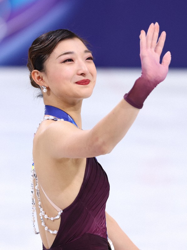 表彰式で観客に手を振る坂本花織＝ミラノ・アイススケートアリーナで2026年2月19日、猪飼健史撮影