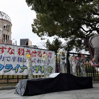 原爆ドーム前で行われたウクライナの平和を訴える集会で、献花する参加者＝広島市中区で、佐藤賢二郎撮影