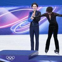 初めてのオリンピックの表彰台に笑顔で飛び乗る、銅メダルに輝いた佐藤駿選手（右）＝ミラノ・アイススケートアリーナで2026年2月13日、吉田航太撮影
