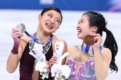 表彰式で銀メダルを手に笑顔を見せる坂本花織選手（左）と銅メダルの中井亜美選手＝ミラノ・アイススケートアリーナで2026年2月19日、猪飼健史撮影