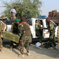 パキスタンとの武力衝突を受け、アフガニスタン東部の国境近くで武器を運ぶタリバン兵ら＝2026年2月27日、ロイター