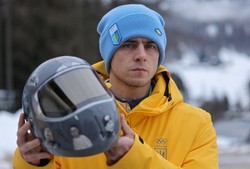 同胞を追悼するためのヘルメットを持つスケルトンのウクライナ代表、ヘラスケビッチ選手＝イタリア北部コルティナダンペッツォで2026年2月12日、ロイター