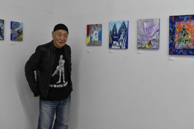 自身が描いた作品の横に立つ泉谷しげるさん＝福岡市博多区で2026年2月22日午後5時21分、山崎あずさ撮影