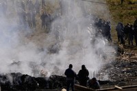 Investigators examine bank notes burned by authorities to prevent people from approaching the scene of a cargo plane that crashed on a highway on Friday evening carrying money, in El Alto, Bolivia, Saturday, Feb. 28, 2026. (AP Photo/Juan Karita)